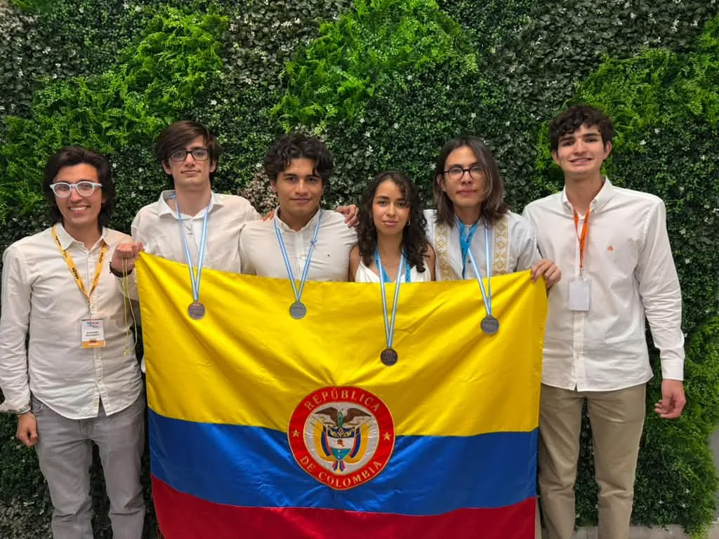 Integrantes de la delegación colombiana posan con sus medallas y la bandera de Colombia durante la Olimpiada Iberoamericana de Matemáticas.